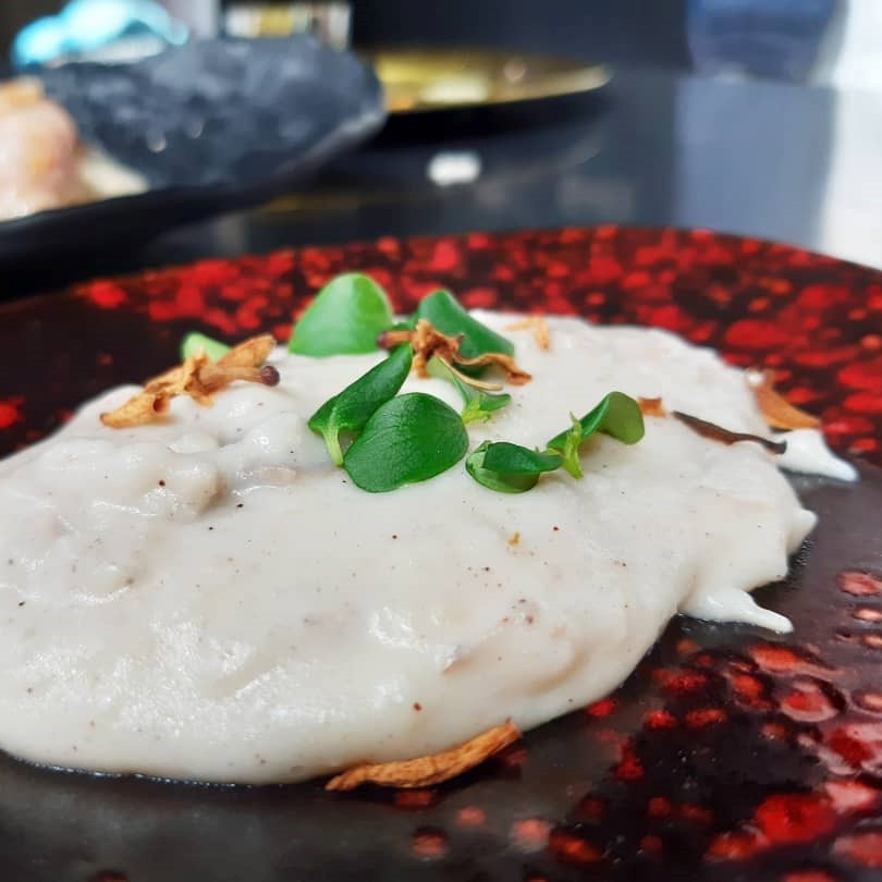 Arroz con leche de cabra con polvo de algarroba y miel de ajo negro y romero, de Mª José Martínez